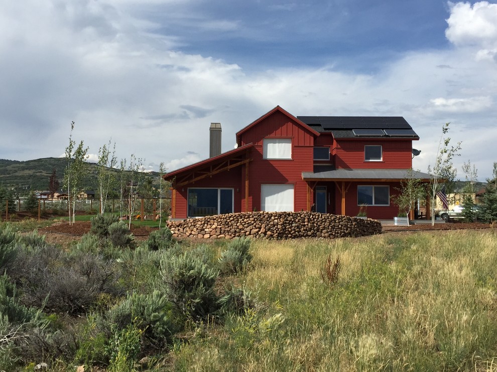 Medium sized and red rural two floor house exterior in Salt Lake City with wood cladding.