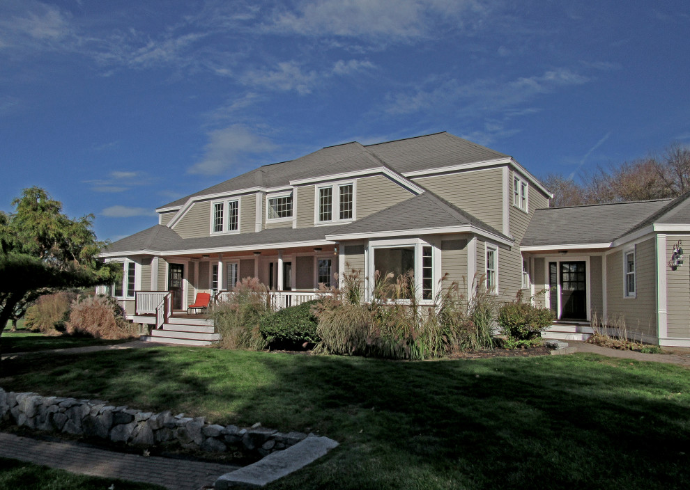 Imagen de fachada de casa gris y gris tradicional grande de dos plantas con revestimientos combinados, tejado a cuatro aguas, tejado de teja de madera y tablilla