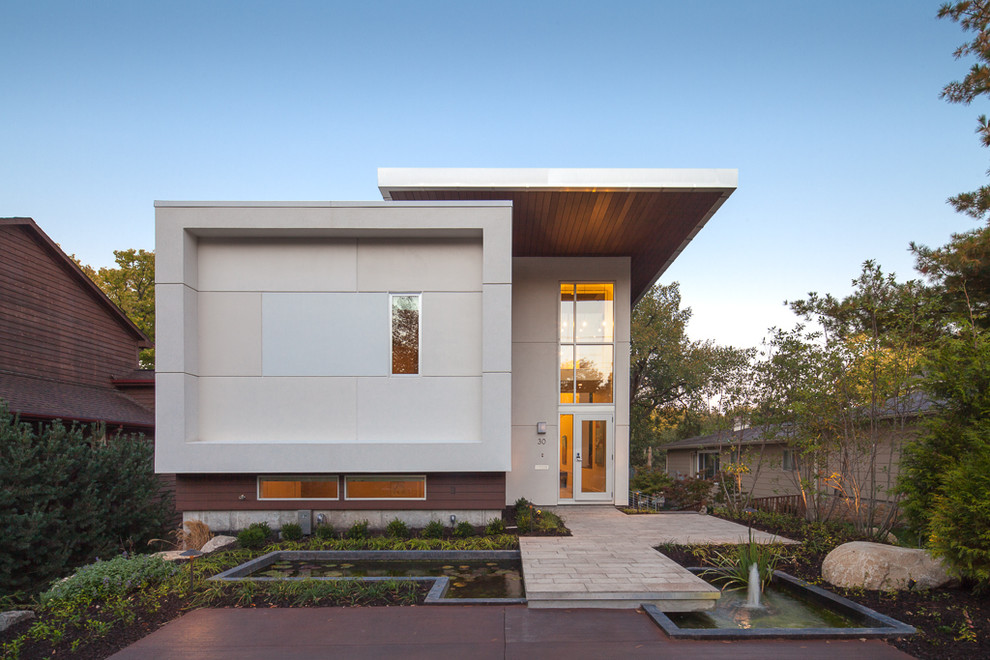 Cette photo montre une façade de maison tendance avec un revêtement mixte et un toit plat.