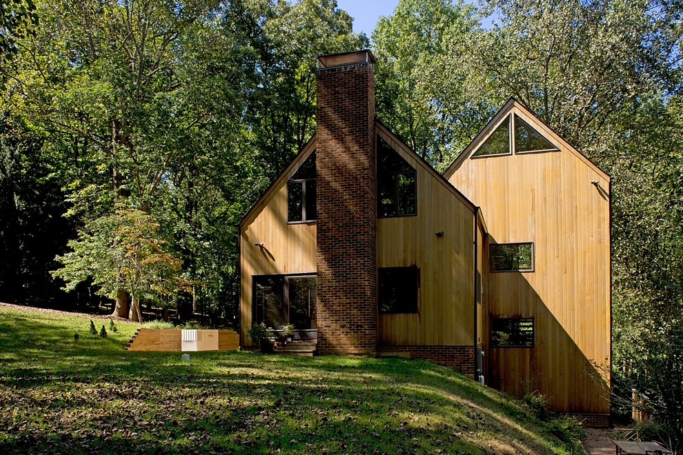 Réalisation d'une façade de maison marron tradition en bois de taille moyenne et à un étage avec un toit à deux pans.