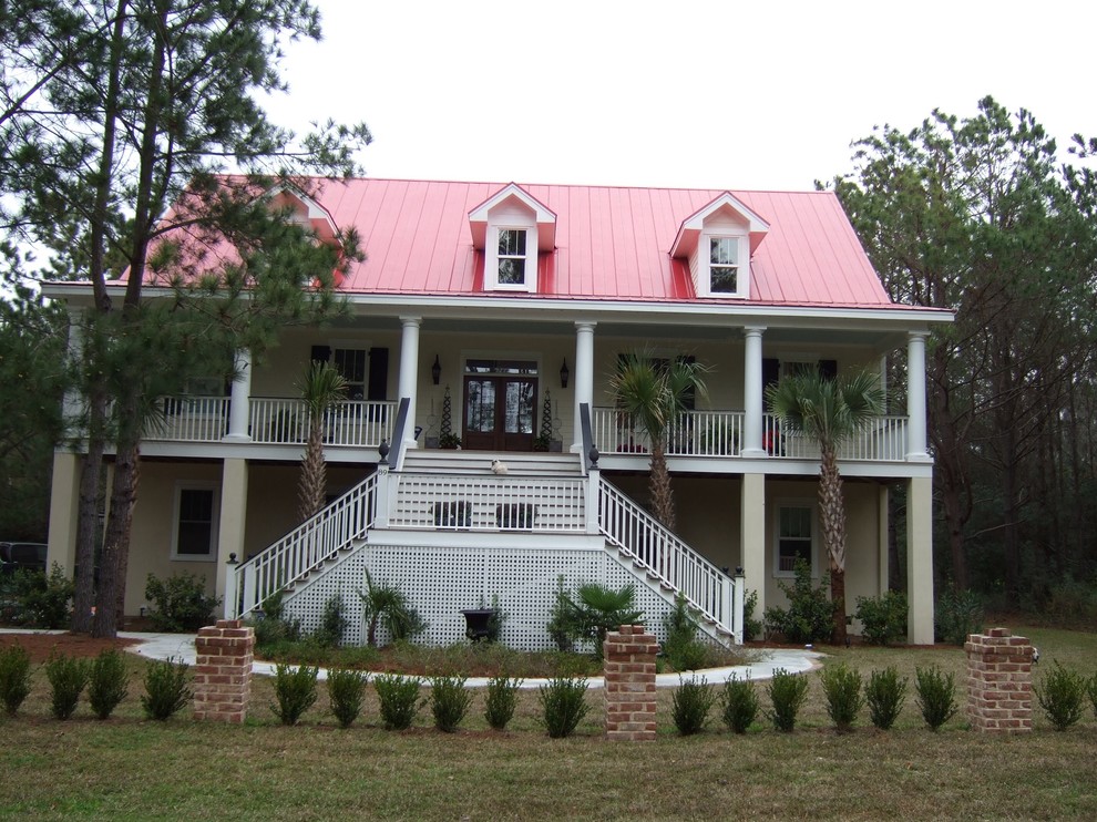 На фото: трехэтажный, бежевый частный загородный дом среднего размера в классическом стиле с комбинированной облицовкой, двускатной крышей и металлической крышей