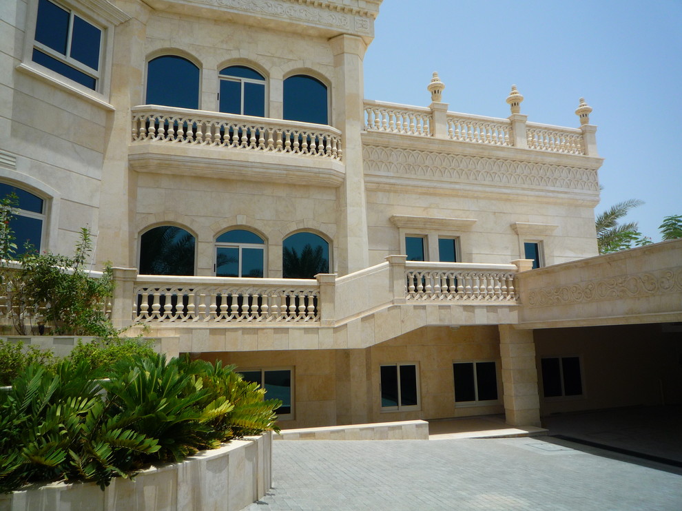 Ejemplo de fachada de casa pareada beige exótica grande de tres plantas con revestimiento de piedra, tejado plano y tejado de teja de barro