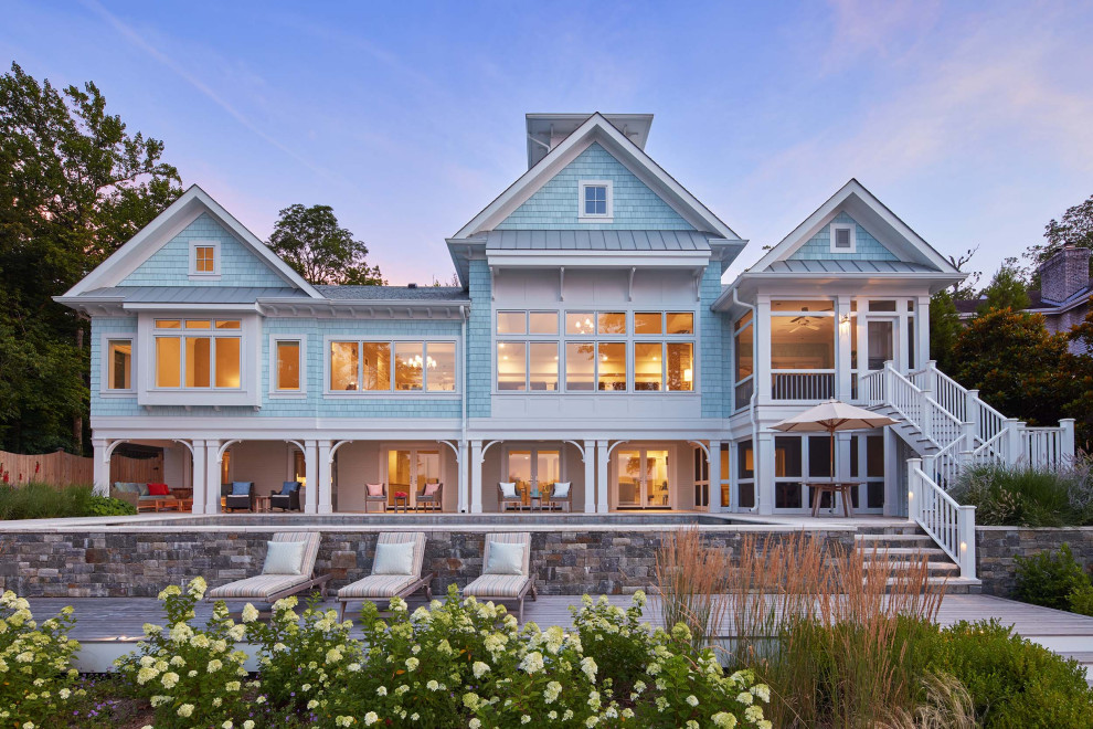 На фото: большой, двухэтажный, синий частный загородный дом в морском стиле