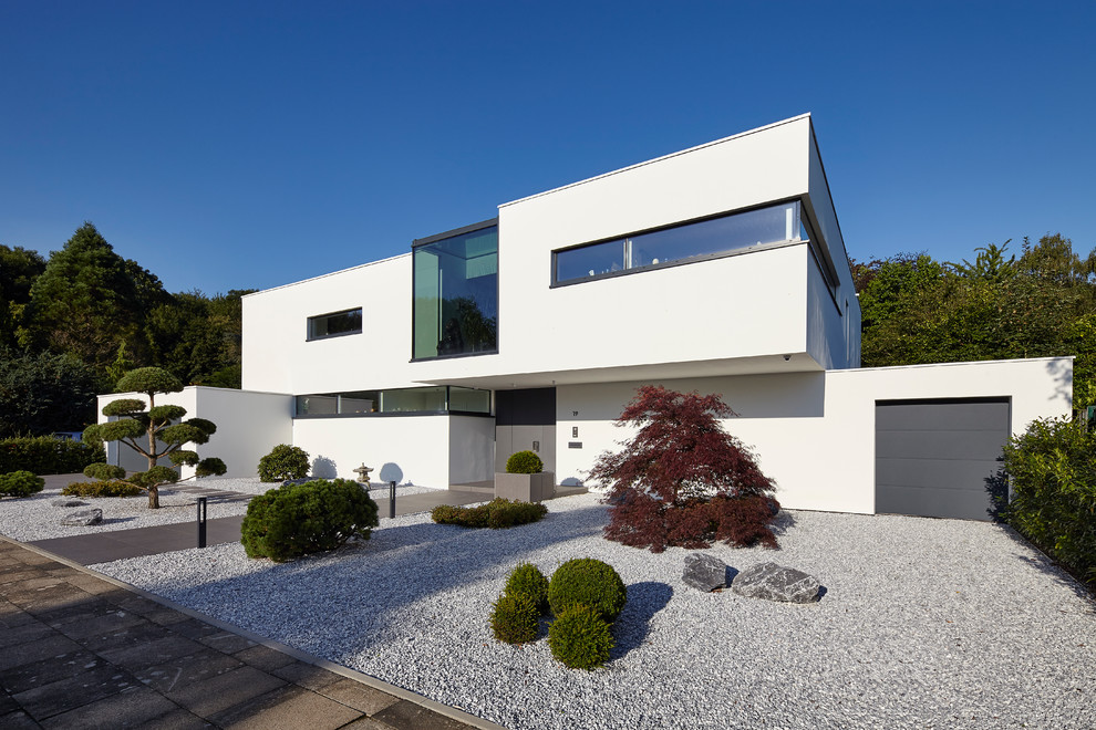 Mittelgroßes, Zweistöckiges Modernes Einfamilienhaus mit weißer Fassadenfarbe, Putzfassade und Flachdach in Köln