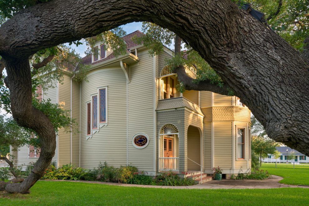 Ejemplo de fachada de casa beige de estilo americano de tamaño medio de dos plantas con revestimiento de madera, tejado a cuatro aguas y tejado de teja de madera