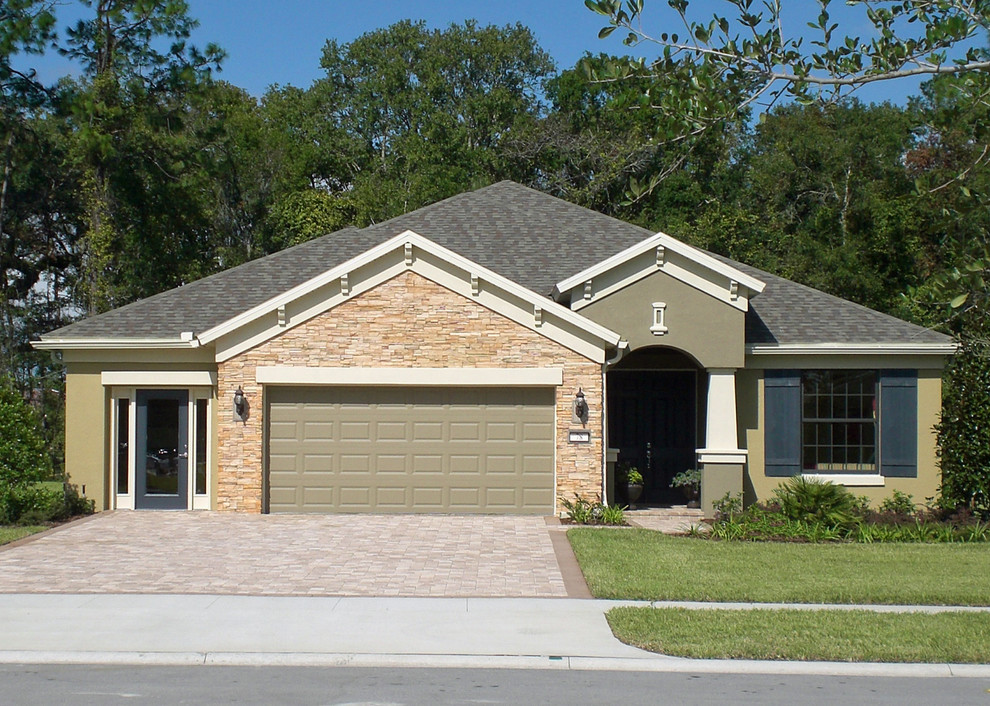 Example of a mid-sized tuscan beige one-story stone exterior home design in Tampa