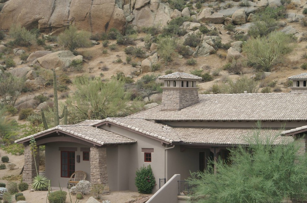 Large southwest gray two-story stucco exterior home photo in Phoenix with a hip roof