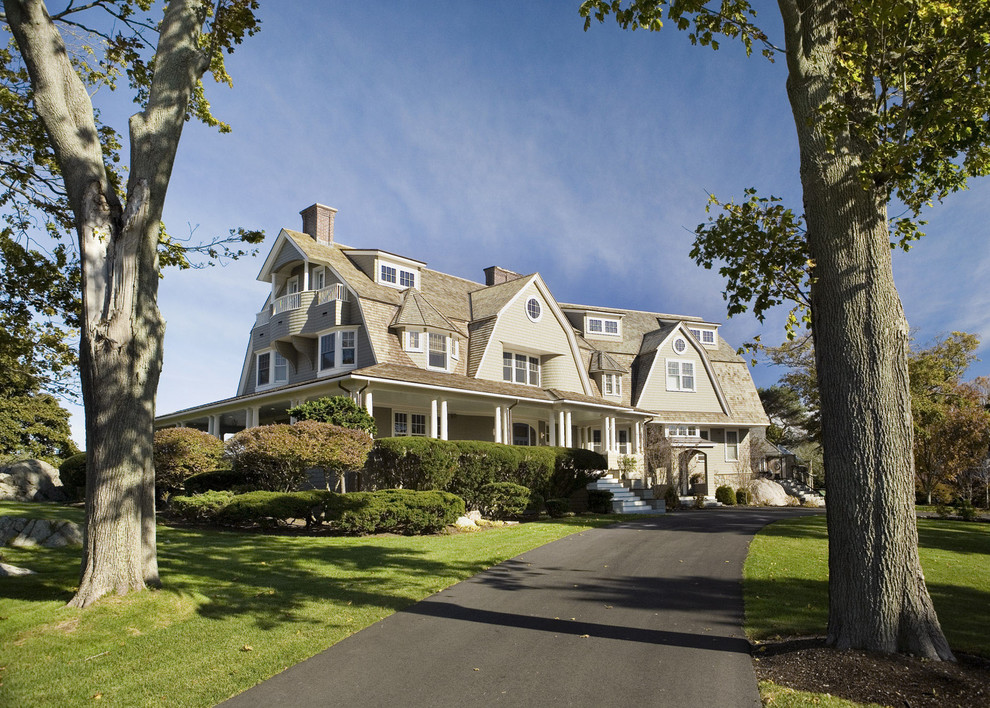 Large coastal house exterior in Boston with three floors, wood cladding and a mansard roof.
