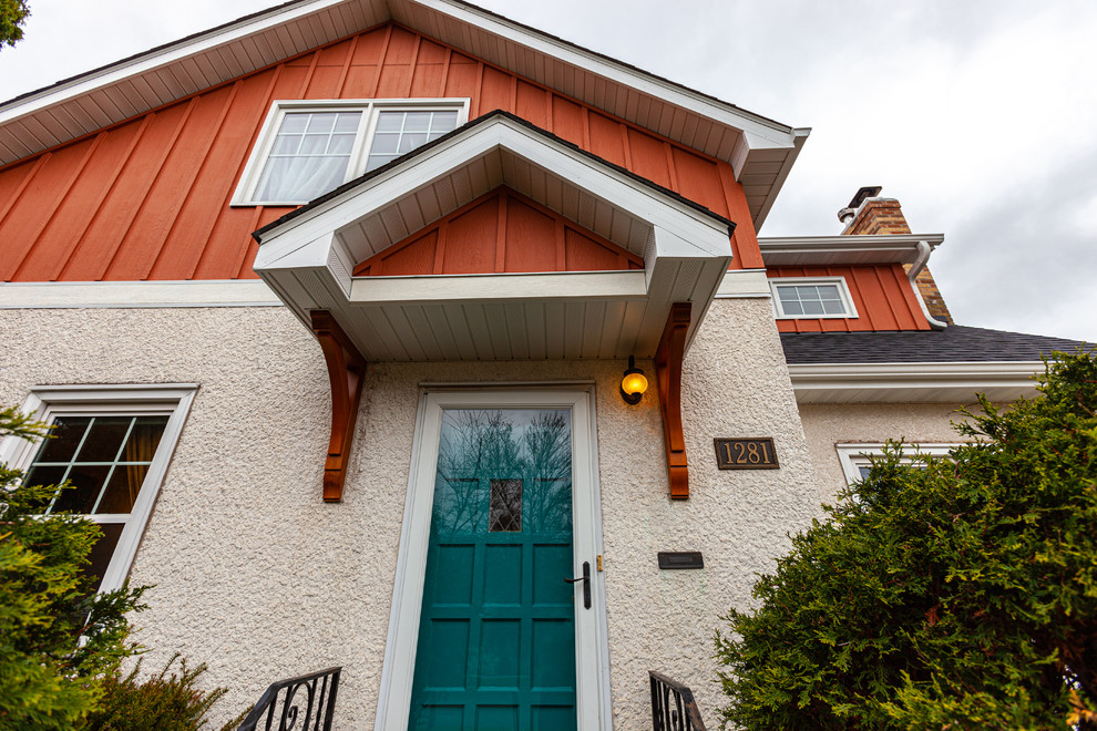 Imagen de fachada de casa beige clásica renovada de dos plantas con revestimiento de estuco
