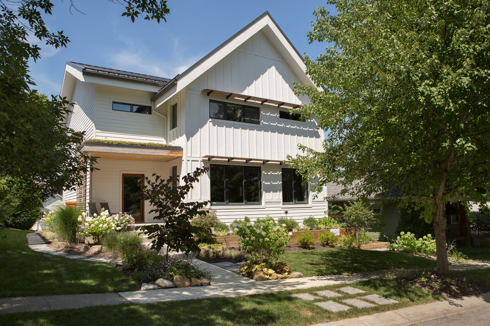Diseño de fachada de casa blanca minimalista de tamaño medio de dos plantas con revestimiento de madera, tejado a cuatro aguas y tejado de metal