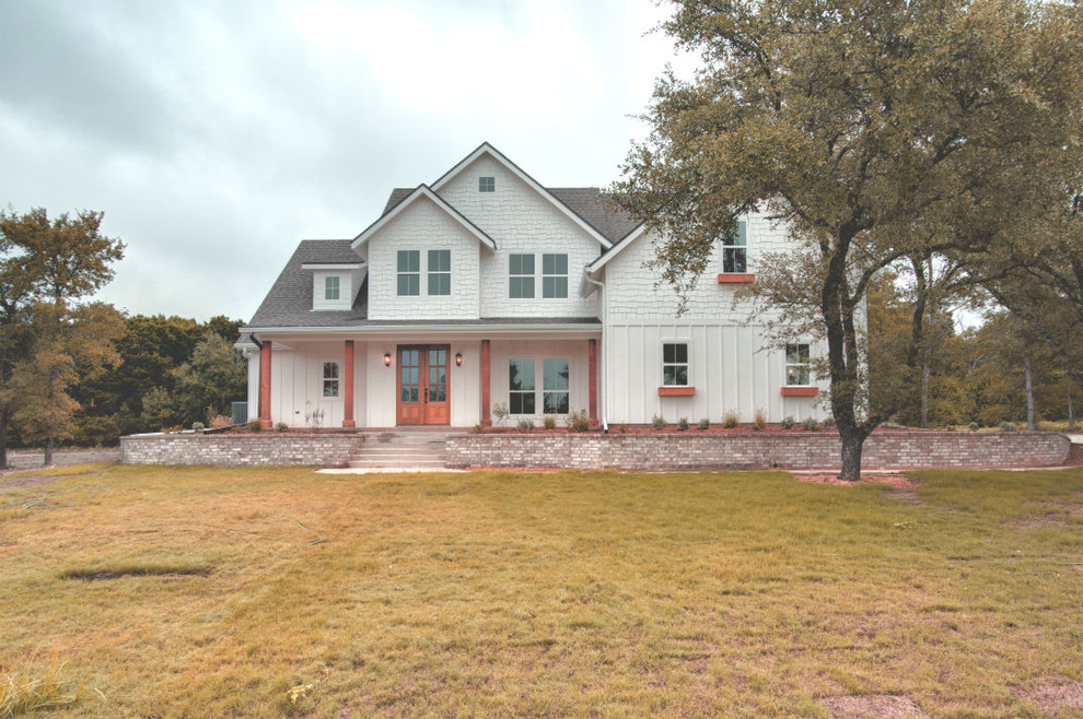 Großes, Zweistöckiges Landhausstil Einfamilienhaus mit Mix-Fassade, weißer Fassadenfarbe, Satteldach und Schindeldach in Austin