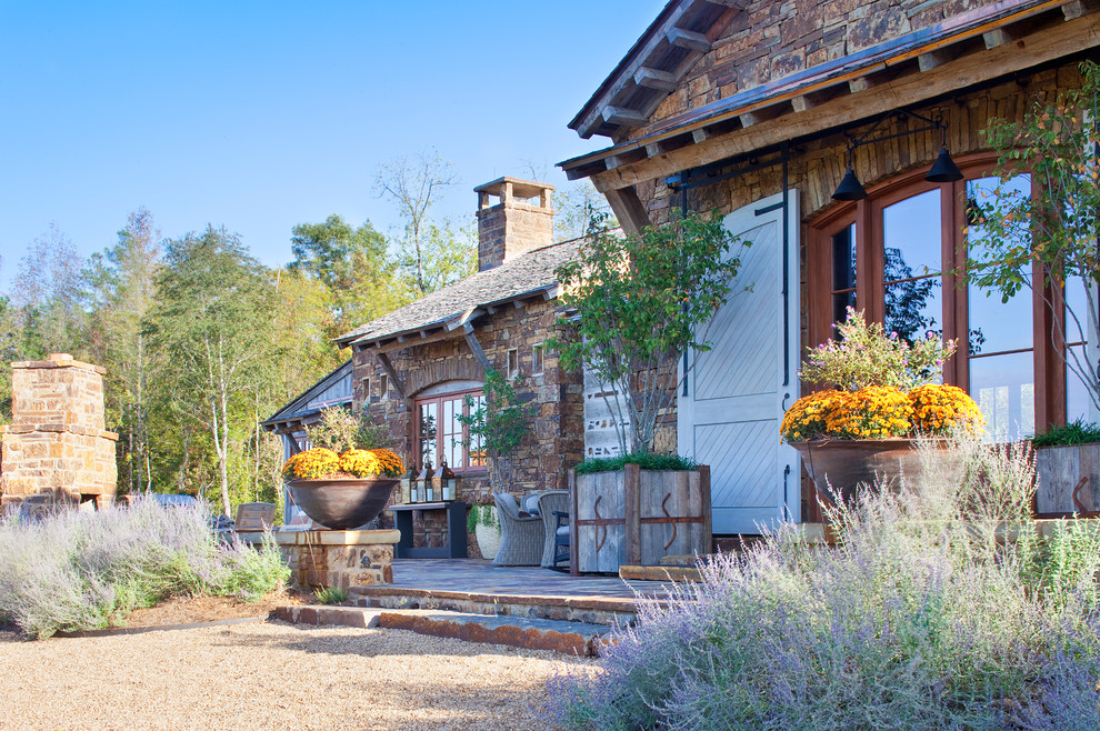 Inspiration for a rustic house exterior in Little Rock with stone cladding.