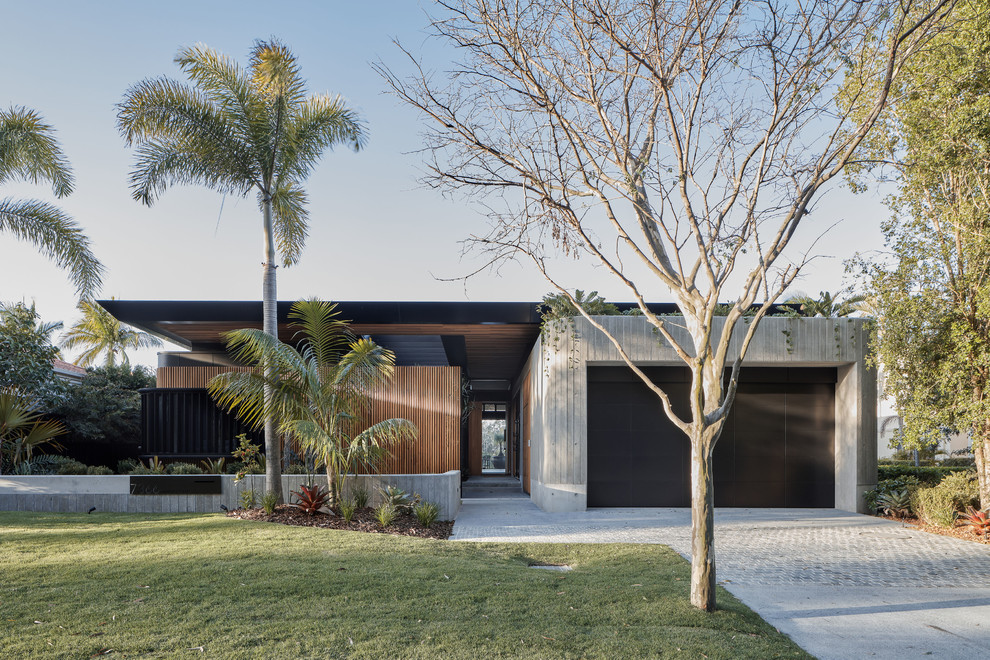 Стильный дизайн: одноэтажный, коричневый частный загородный дом в стиле лофт с комбинированной облицовкой и плоской крышей - последний тренд