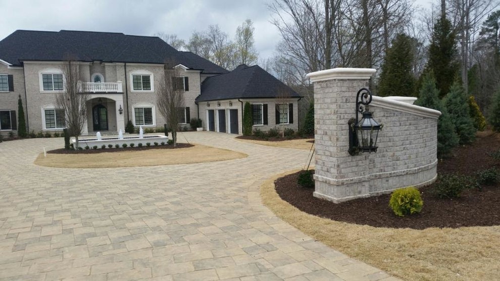 Large elegant gray two-story stone exterior home photo in Atlanta with a hip roof
