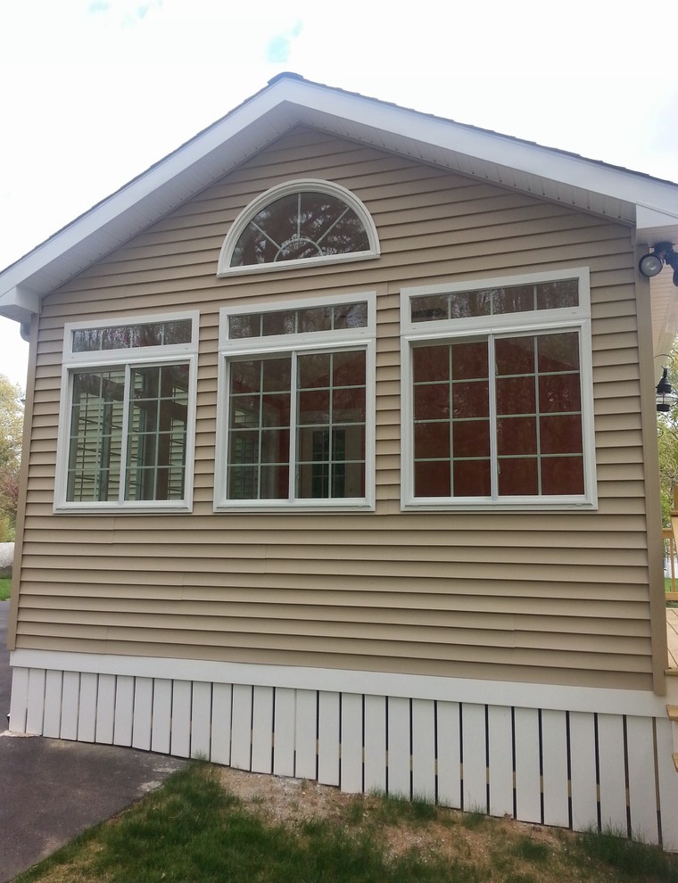 Diseño de fachada beige clásica de tamaño medio de dos plantas con revestimiento de vinilo y tejado a doble faldón