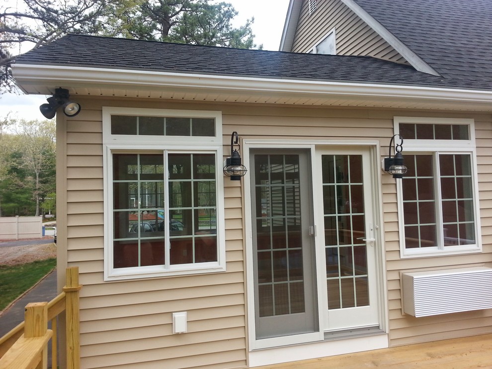 Medium sized and beige traditional two floor house exterior in Providence with vinyl cladding and a mansard roof.