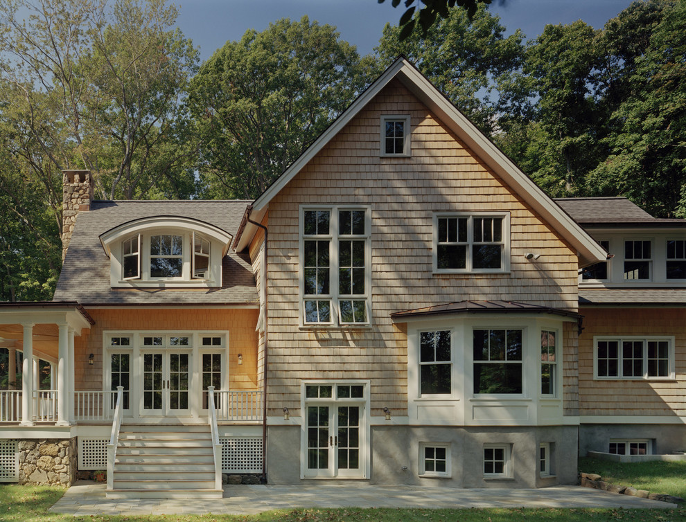 Идея дизайна: большой, бежевый, деревянный частный загородный дом в классическом стиле с разными уровнями и полувальмовой крышей