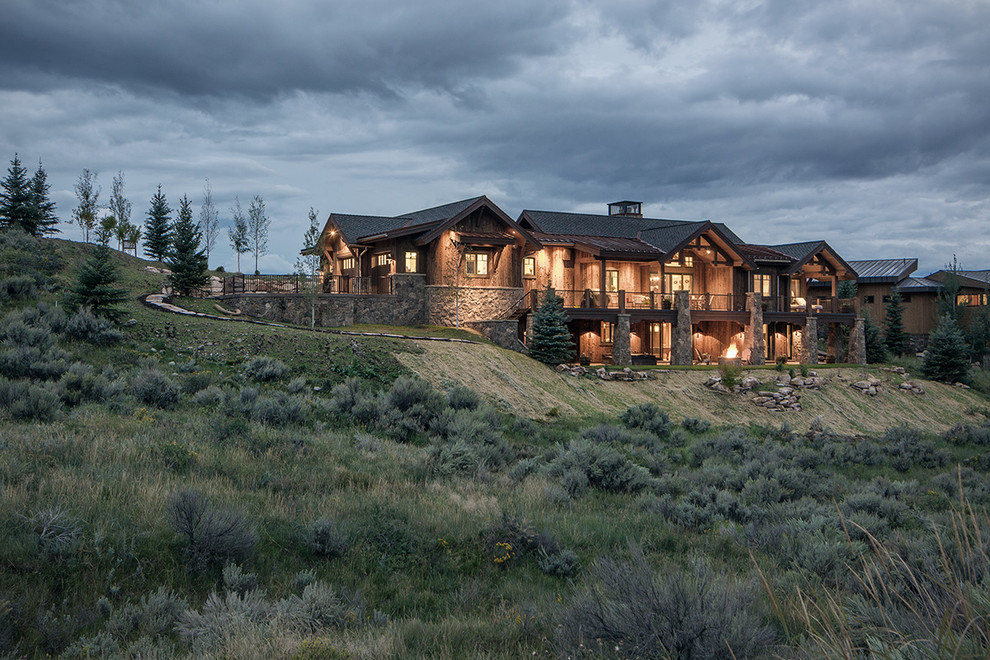 Inspiration for an expansive and brown rustic two floor house exterior in Salt Lake City with wood cladding and a pitched roof.