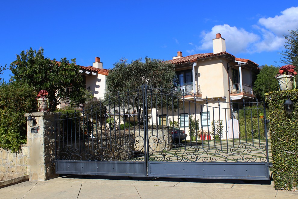Mittelgroßes, Zweistöckiges Mediterranes Haus mit Putzfassade, beiger Fassadenfarbe und Satteldach in Santa Barbara