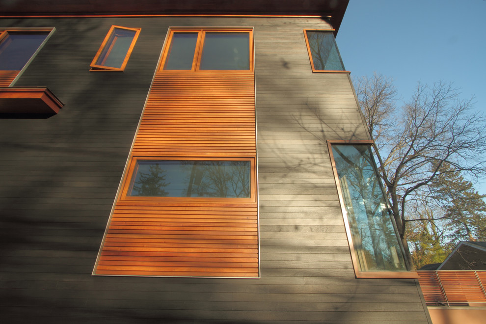 Imagen de fachada de casa gris actual grande de una planta con revestimiento de madera, tejado plano y tejado de teja de madera