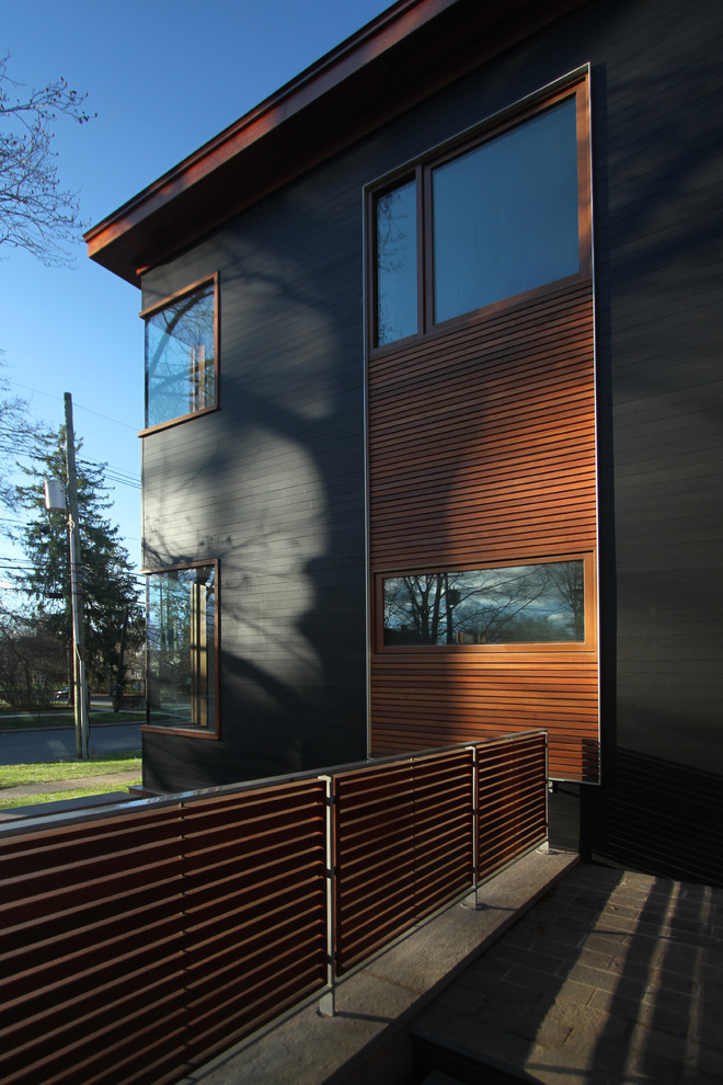 Cette image montre une grande façade de maison grise design en bois de plain-pied avec un toit plat et un toit en shingle.