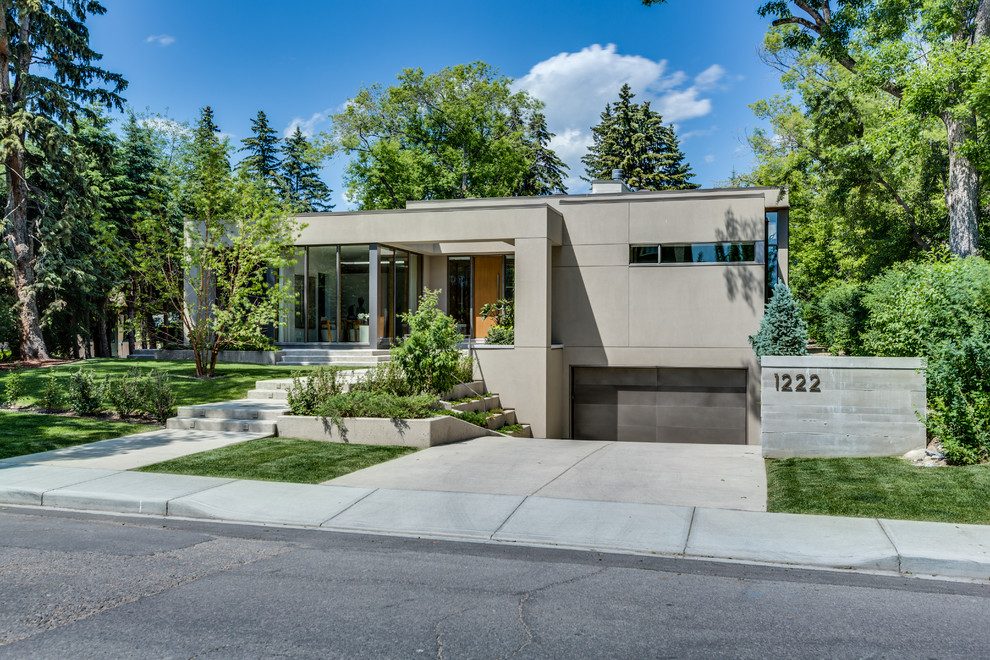 Inspiration for a beige and large modern bungalow render detached house in Calgary with a flat roof.