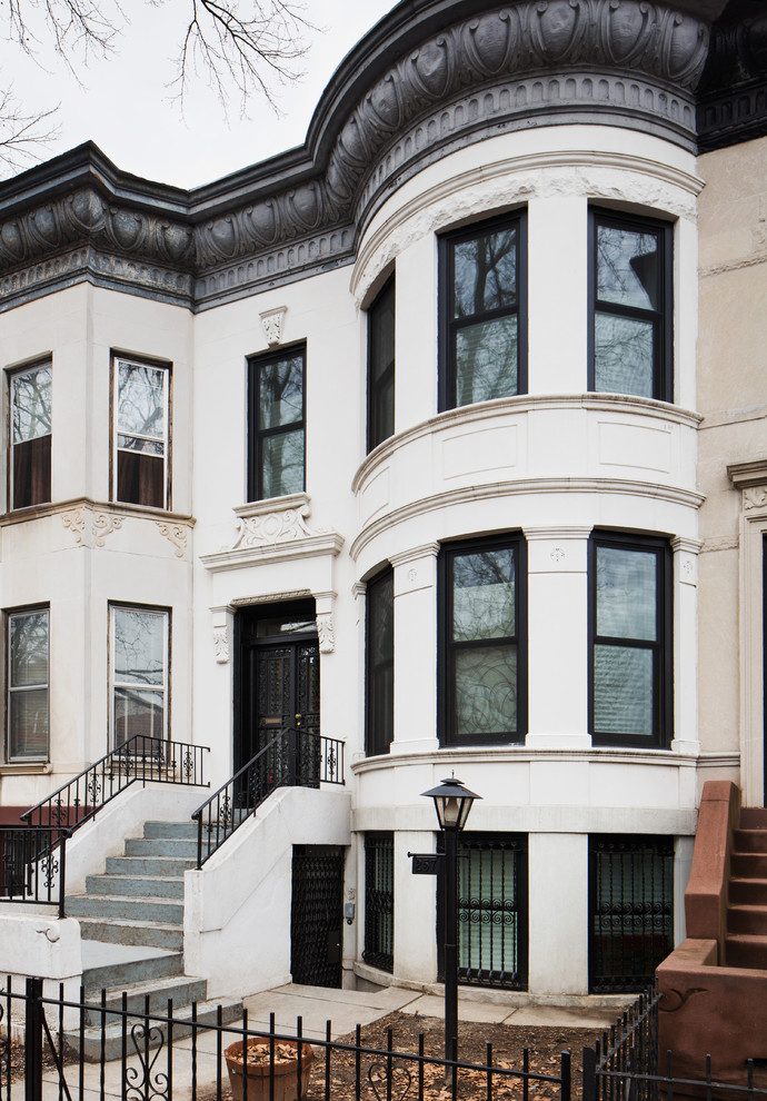 Mittelgroßes, Dreistöckiges Klassisches Haus mit Betonfassade und weißer Fassadenfarbe in New York