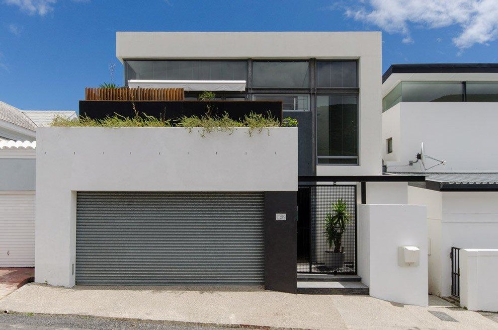 Ejemplo de fachada gris minimalista de dos plantas con revestimiento de hormigón y tejado plano