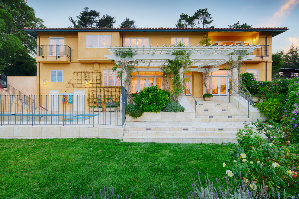 Источник вдохновения для домашнего уюта: большой, двухэтажный, желтый дом в средиземноморском стиле с облицовкой из цементной штукатурки и вальмовой крышей