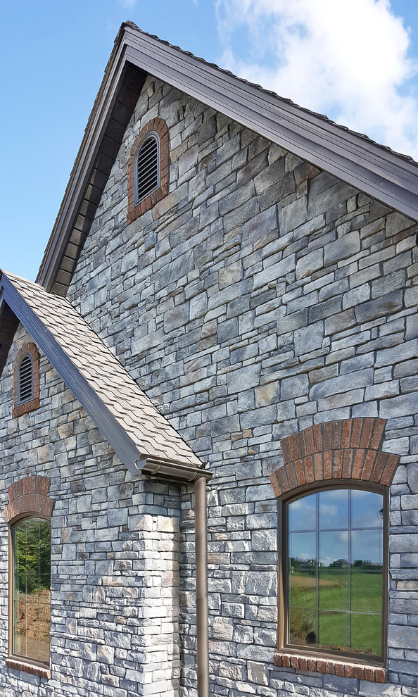 Example of a large trendy gray one-story stone exterior home design in Cleveland with a tile roof