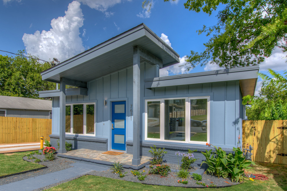 This is an example of a medium sized and blue modern bungalow detached house in Austin with concrete fibreboard cladding, a lean-to roof and a shingle roof.