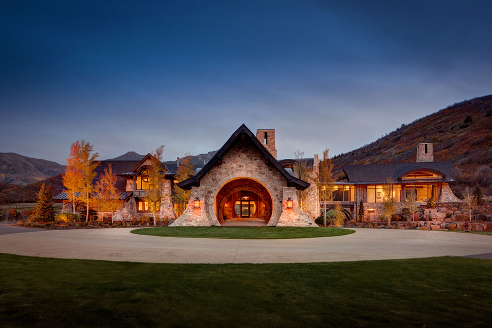 Inspiration for a rustic beige two-story stone exterior home remodel in Salt Lake City with a mixed material roof