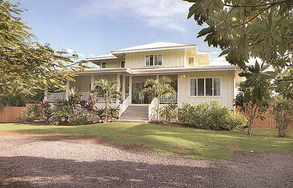 Example of a large island style beige two-story wood house exterior design in Hawaii with a hip roof and a shingle roof