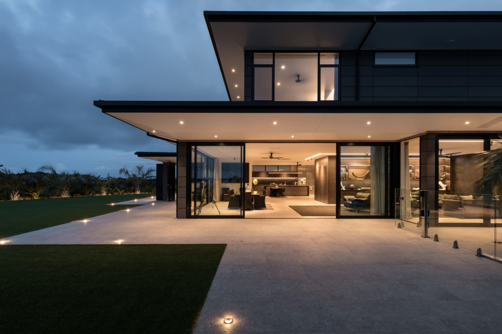 На фото: огромный, трехэтажный, серый частный загородный дом в стиле модернизм с облицовкой из бетона, плоской крышей и металлической крышей с