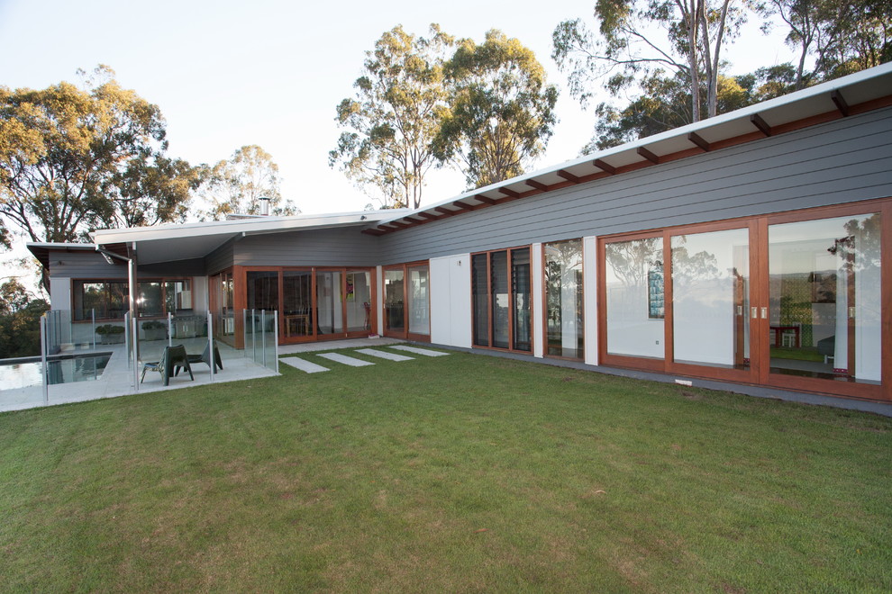 Großes, Einstöckiges Modernes Haus mit Faserzement-Fassade und grauer Fassadenfarbe in Brisbane