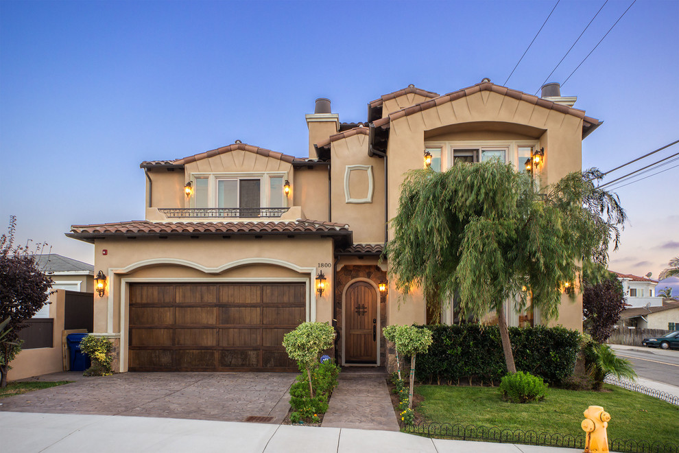 Example of a mid-sized tuscan beige two-story stucco gable roof design in Los Angeles