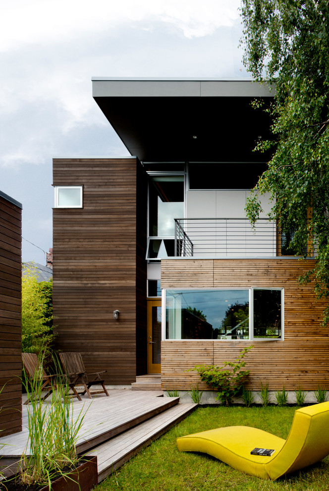 Imagen de fachada contemporánea de dos plantas con revestimiento de madera