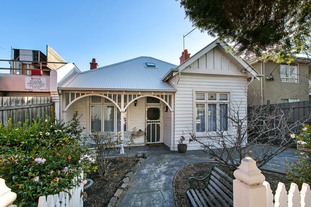 This is an example of a white romantic two floor house exterior in Melbourne with wood cladding.
