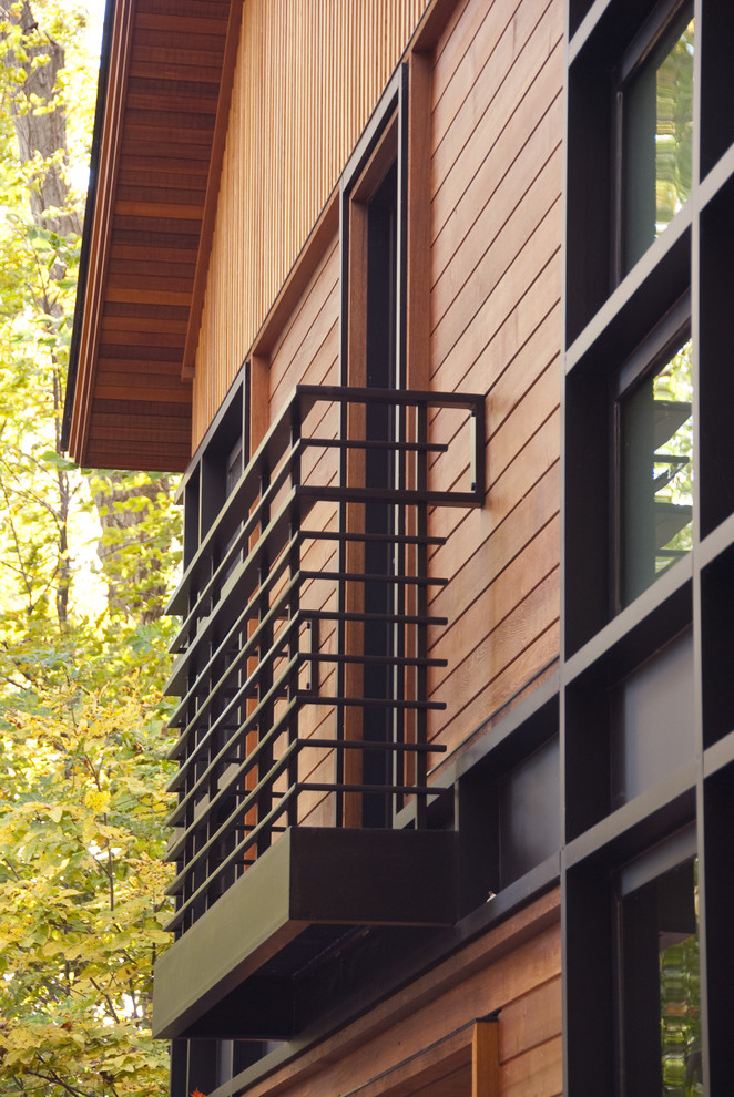 Inspiration pour une grande façade de maison design en bois à deux étages et plus avec un toit à deux pans et un toit en métal.