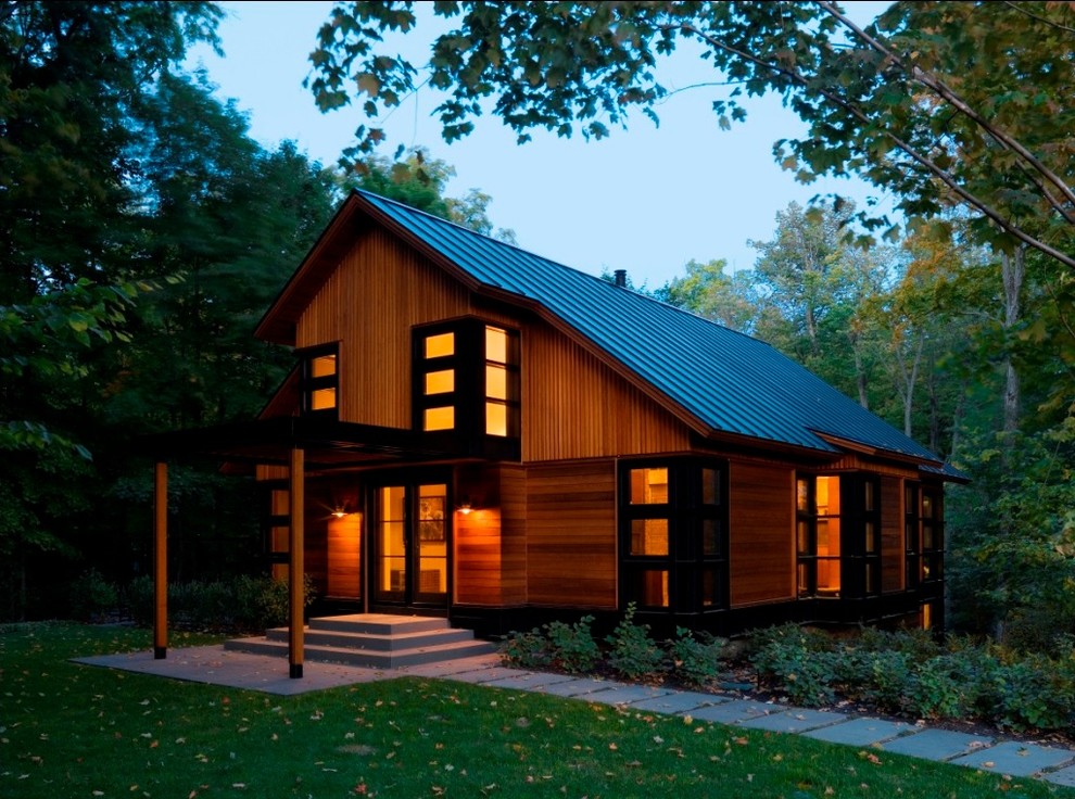Cette photo montre une grande façade de maison chic en bois à deux étages et plus avec un toit à deux pans et un toit en métal.