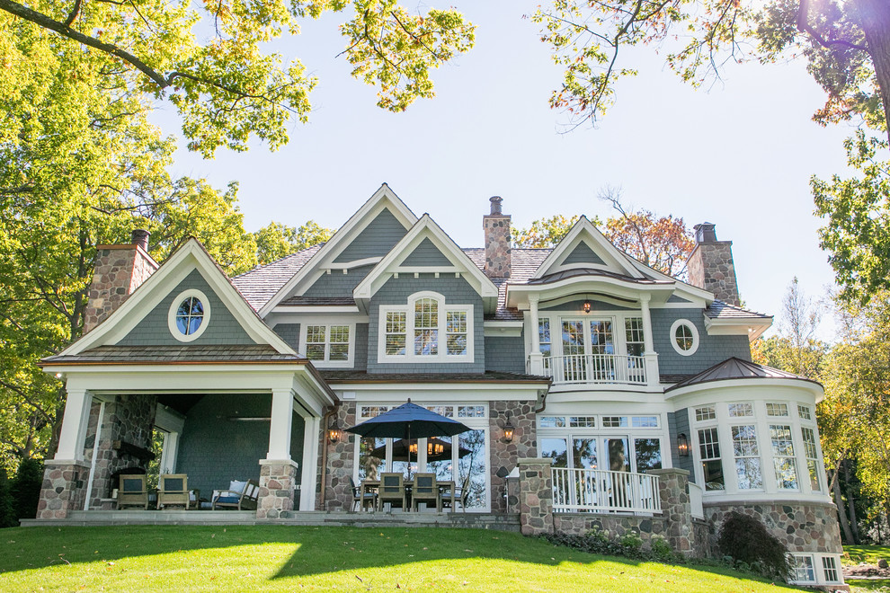 Inspiration for a large coastal blue two-story wood exterior home remodel in Milwaukee with a shingle roof