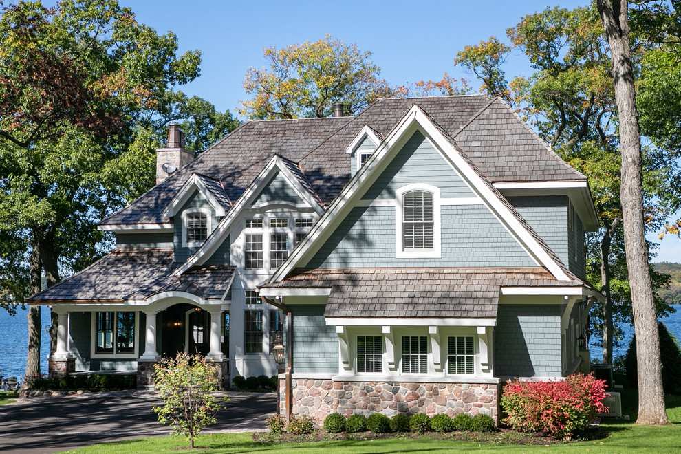 Inspiration for a large coastal blue two-story wood exterior home remodel in Milwaukee with a shingle roof