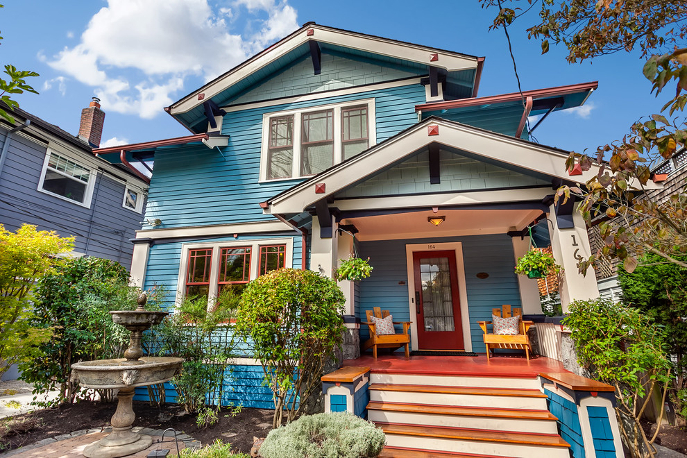 Immagine della villa blu american style a tre piani con rivestimento in legno