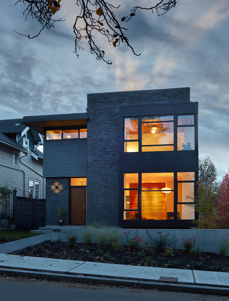 Inspiration pour une petite façade de maison noire minimaliste en brique à deux étages et plus avec un toit plat.