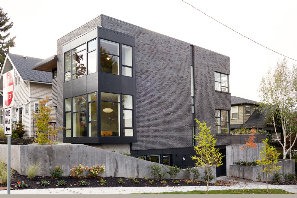 Diseño de fachada de casa negra moderna pequeña de tres plantas con revestimiento de ladrillo, tejado plano y tejado de varios materiales