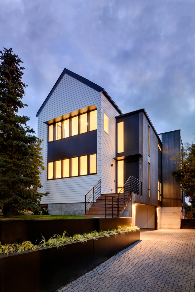 Großes, Dreistöckiges Modernes Einfamilienhaus mit Mix-Fassade, schwarzer Fassadenfarbe, Flachdach und Misch-Dachdeckung in Seattle