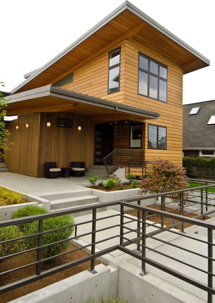 Cette image montre une façade de maison design en bois à un étage avec un toit plat.