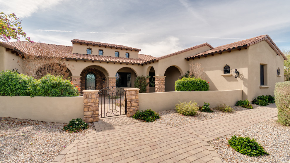 Mid-sized mediterranean beige one-story stucco exterior home idea in Phoenix with a tile roof
