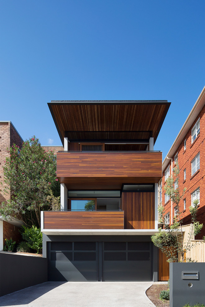 Design ideas for a large contemporary house exterior in Sydney with three floors, wood cladding and a flat roof.
