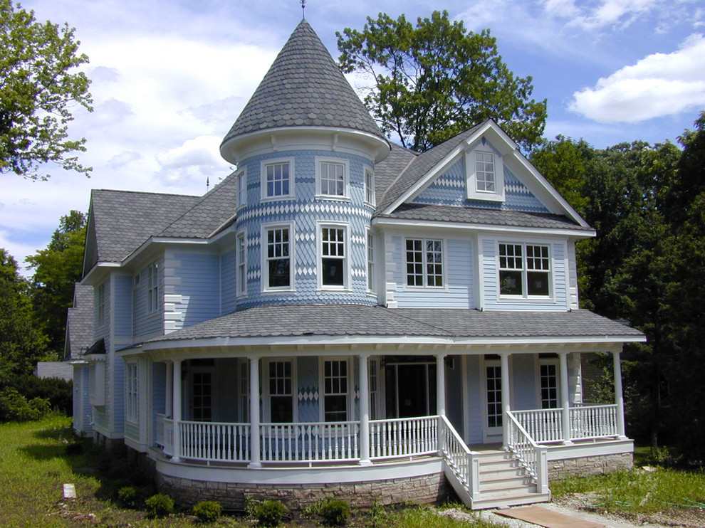 Esempio della facciata di una casa grande blu vittoriana a tre piani con rivestimenti misti e tetto a capanna